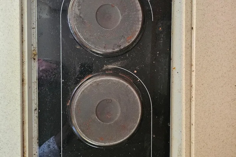 Slide: The Image of Close-up of a vintage stovetop with two rusty burners, Regal Commodore 292, 1999 model. - 29