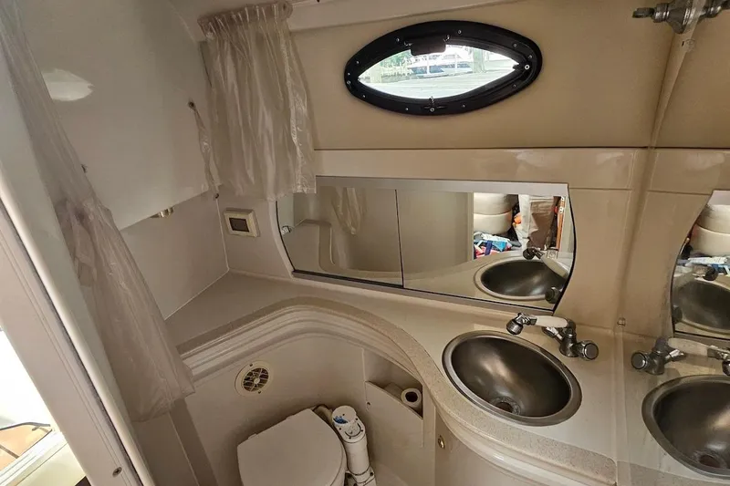 Slide: The Image of 1999 Regal Commodore 292 boat bathroom with sink, mirror, and toilet. - 30