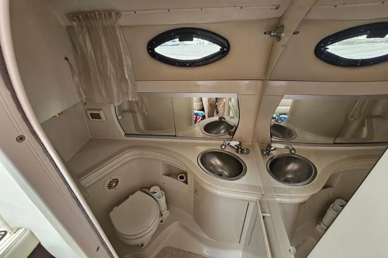 Slide: The Image of Interior of 1999 Regal Commodore 292 boat bathroom with dual sinks and toilet. - 31