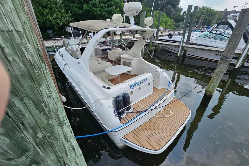 Slide: The Image of 1999 Regal Commodore 292 boat docked, featuring spacious deck and seating area. - 4