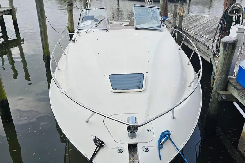 Slide: The Image of 1999 Regal Commodore 292 boat docked at marina, featuring sleek white design and open deck. - 5