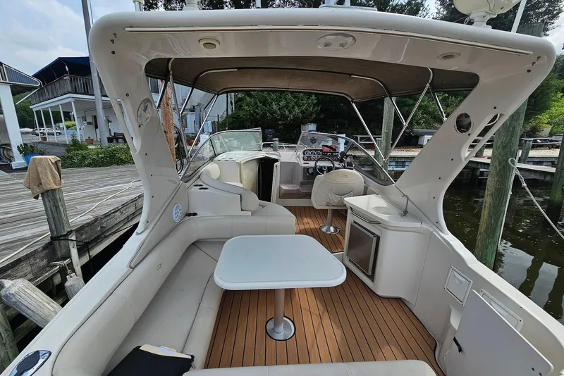 Slide: The Image of 1999 Regal Commodore 292 boat interior with seating, table, and helm at a dock. - 8