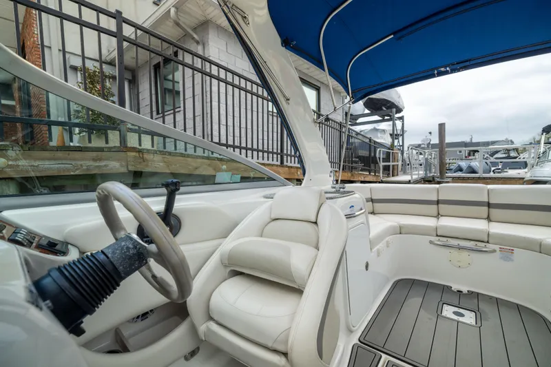 Slide: The Image of 2008 Chaparral 256 SSi boat interior with white seating and blue canopy. - 16