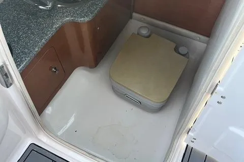 Slide: The Image of 2008 Chaparral 256 SSi boat interior with compact portable toilet and sink. - 8