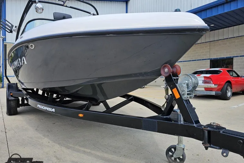 Slide: The Image of 2014 Moomba Outback V boat on trailer, parked near a red sports car. - 12