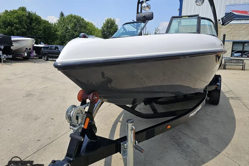 Slide: The Image of 2014 Moomba Outback V boat on trailer, parked outdoors, showcasing sleek design. - 16