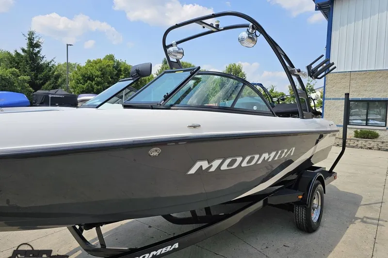 Slide: The Image of 2014 Moomba Outback V boat on trailer, parked outdoors under a clear sky. - 18