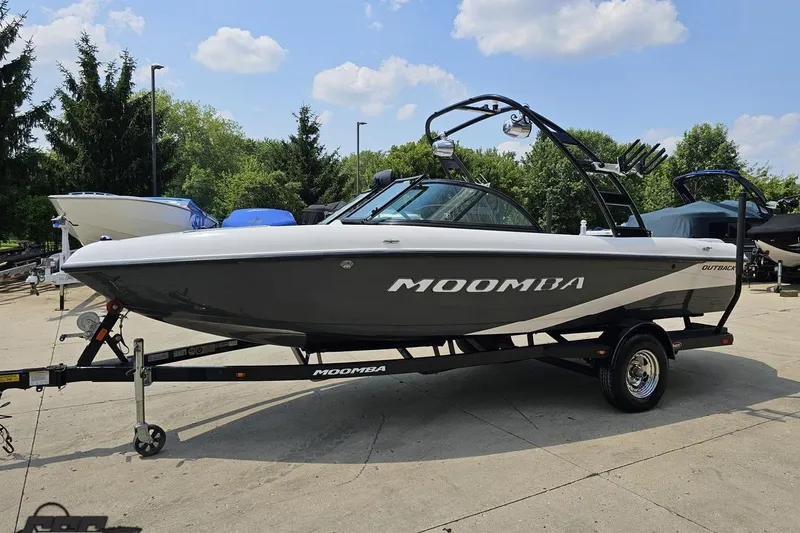 Slide: The Image of 2014 Moomba Outback V boat on trailer, parked outdoors under a clear sky. - 19