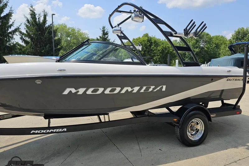 Slide: The Image of 2014 Moomba Outback V boat on trailer, parked outdoors under a clear sky. - 22