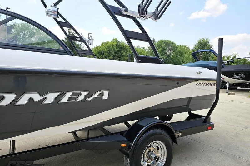 Slide: The Image of 2014 Moomba Outback V boat on trailer, side view with trees in background. - 26