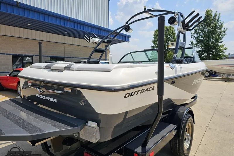 Slide: The Image of 2014 Moomba Outback V boat on trailer, parked outdoors near a building. - 33