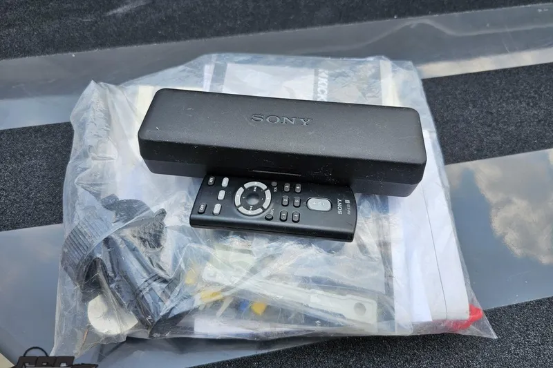 Slide: The Image of Sony remote and accessories in a plastic bag, related to 2014 Moomba Outback V. - 35