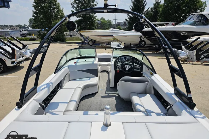 Slide: The Image of 2014 Moomba Outback V boat interior with seating and steering wheel, parked outdoors. - 41