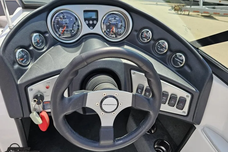 Slide: The Image of Steering wheel and dashboard of 2014 Moomba Outback V boat with gauges and controls. - 61