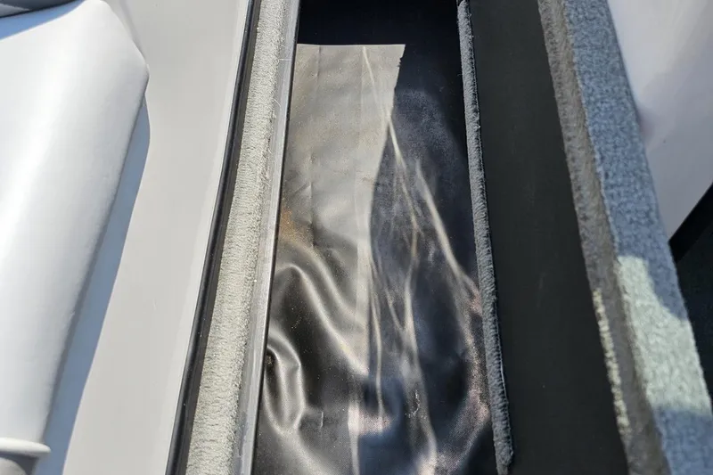 Slide: The Image of 2014 Moomba Outback V interior storage compartment with gray and black materials. - 67