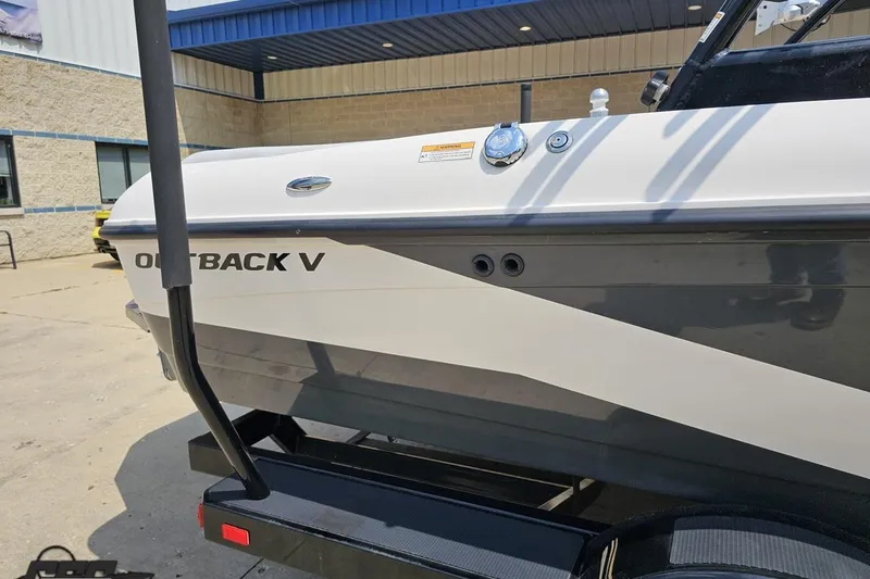 Slide: The Image of 2014 Moomba Outback V boat side view, parked outdoors on a trailer. - 7