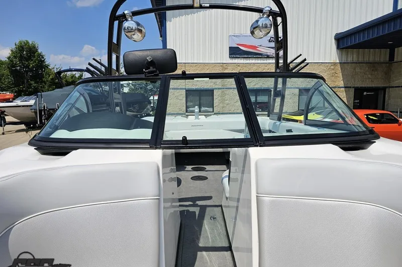 Slide: The Image of 2014 Moomba Outback V boat interior with windshield and tower, parked outdoors. - 75