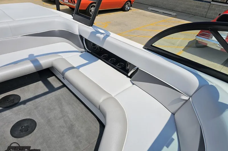 Slide: The Image of 2014 Moomba Outback V boat interior with white and gray seating, parked outdoors. - 79