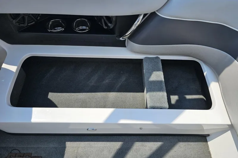 Slide: The Image of 2014 Moomba Outback V interior storage compartment with cup holders and speakers. - 83