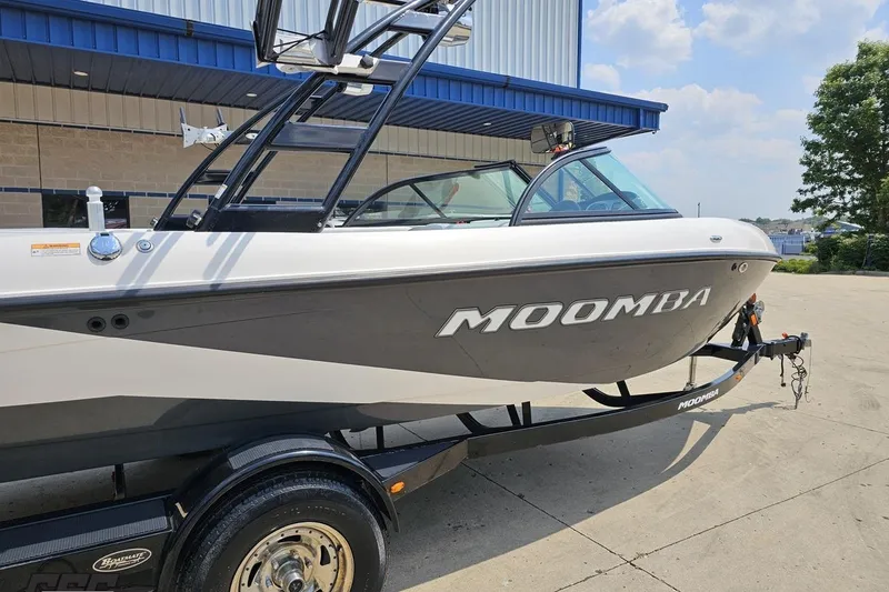 Slide: The Image of 2014 Moomba Outback V boat on trailer, parked outdoors near a building. - 9