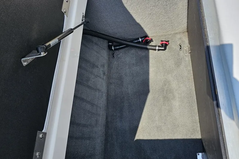 Slide: The Image of Interior storage compartment of a 2014 Moomba Outback V boat, featuring carpeted flooring. - 90