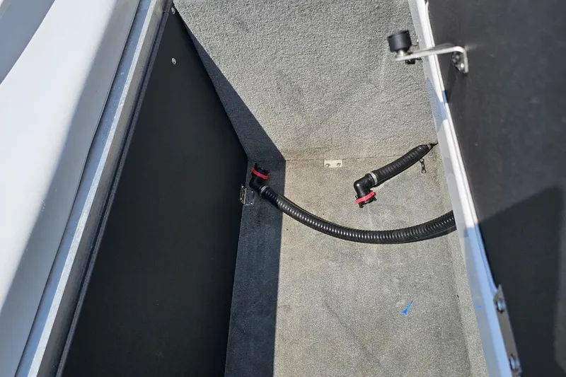 Slide: The Image of 2014 Moomba Outback V storage compartment with interior carpeting and visible wiring. - 91