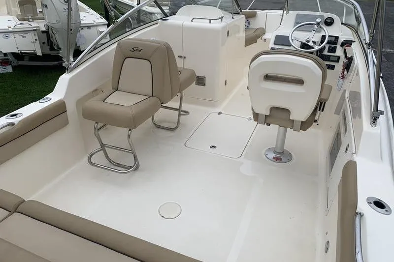 Slide: The Image of 2018 Scout 225 Dorado boat interior with beige seating and modern dashboard. - 10