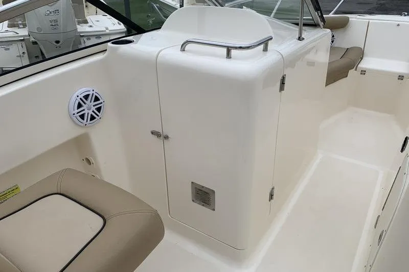 Slide: The Image of 2018 Scout 225 Dorado boat interior with beige seating and storage compartment. - 13