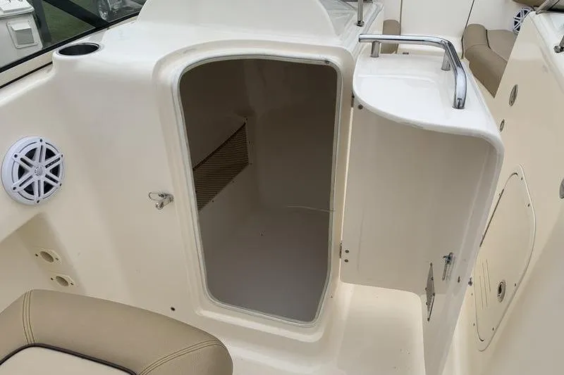 Slide: The Image of 2018 Scout 225 Dorado boat storage compartment with open door and speaker. - 14