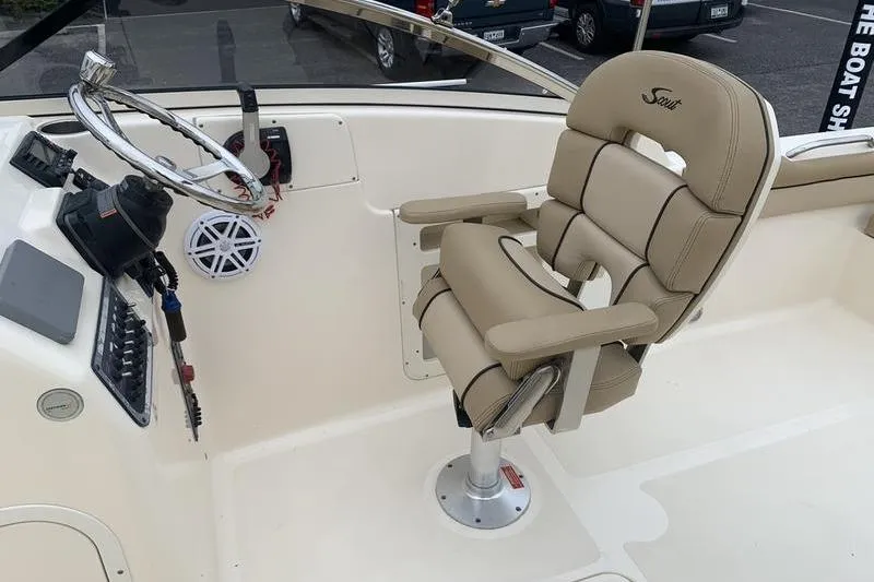 Slide: The Image of 2018 Scout 225 Dorado boat helm with beige captain's chair and steering wheel. - 15