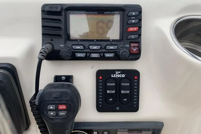 Slide: The Image of 2018 Scout 225 Dorado boat dashboard with radio and Lenco trim tab controls. - 19