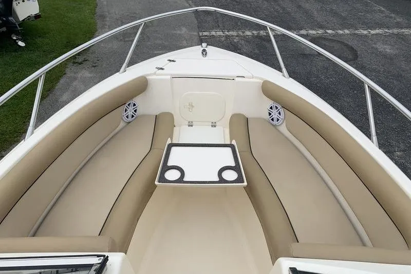 Slide: The Image of 2018 Scout 225 Dorado boat interior with beige seating and cup holders. - 24