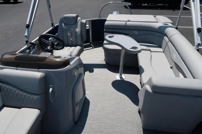 Slide: The Image of 2022 Bennington 20 SLM pontoon boat interior with plush seating and steering console. - 13