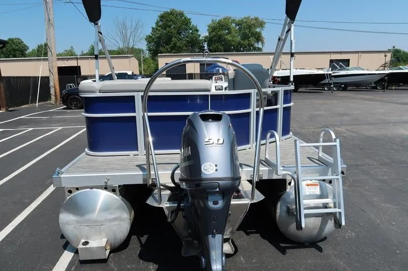 Slide: The Image of 2022 Bennington 20 SLM pontoon boat with Yamaha outboard motor in a parking lot. - 2