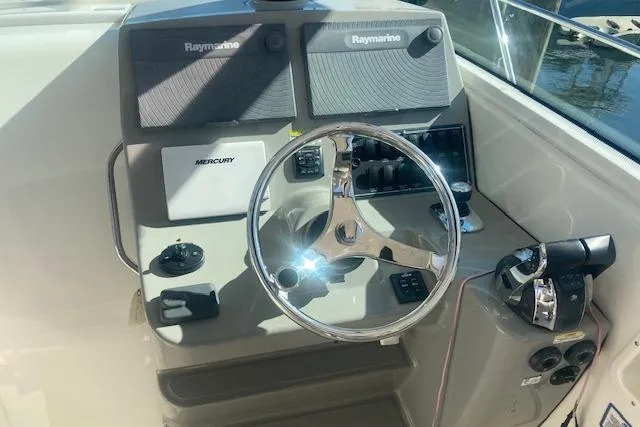 Slide: The Image of 2016 Boston Whaler 315 Conquest helm with Raymarine electronics and Mercury controls. - 5