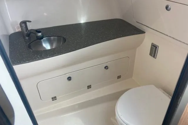 Slide: The Image of 2016 Boston Whaler 315 Conquest boat bathroom with sink and toilet. - 8