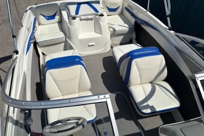 Slide: The Image of 2006 Bayliner 185 Bowrider interior with white and blue seating, steering wheel, and storage compartments. - 10