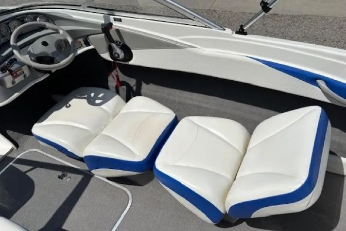 Slide: The Image of 2006 Bayliner 185 Bowrider interior with white and blue seating, steering wheel, and dashboard. - 20