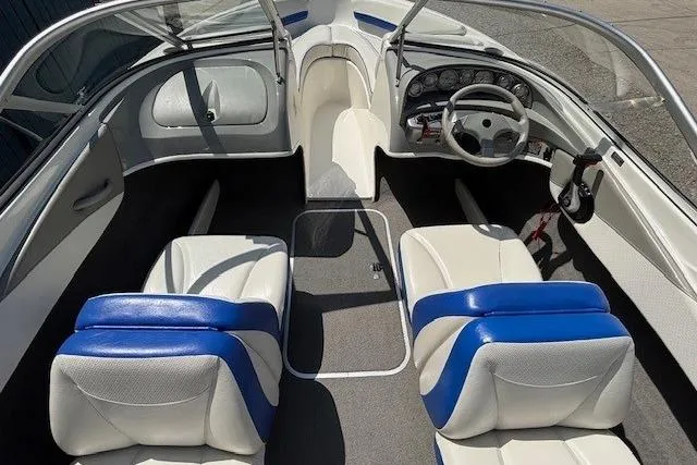 Slide: The Image of 2006 Bayliner 185 Bowrider interior with blue and white seating, steering wheel, and dashboard. - 21