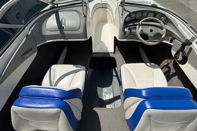Slide: The Image of 2006 Bayliner 185 Bowrider interior with white and blue seating, steering wheel, and dashboard. - 22