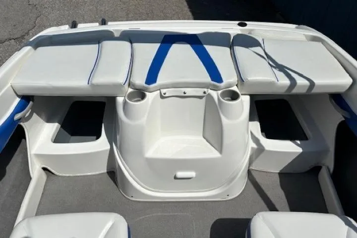 Slide: The Image of 2006 Bayliner 185 Bowrider interior with white and blue seating, cup holders, and storage compartments. - 26