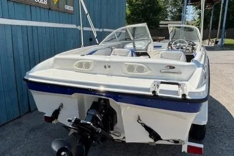 Slide: The Image of 2006 Bayliner 185 Bowrider boat, rear view, parked outdoors near blue building. - 4