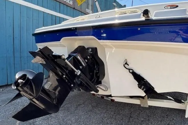 Slide: The Image of 2006 Bayliner 185 Bowrider boat stern with outboard motor, blue and white design. - 5
