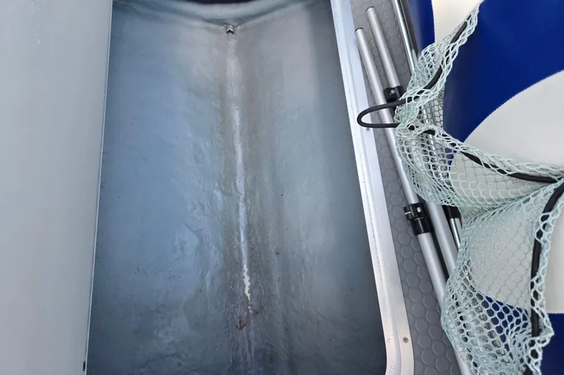 Slide: The Image of Interior view of a 2006 Bayliner 195 Classic boat with storage compartment and netting. - 12