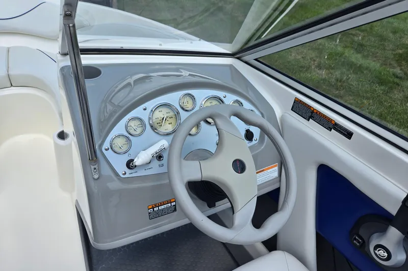 Slide: The Image of 2006 Bayliner 195 Classic boat dashboard with steering wheel and gauges. - 13