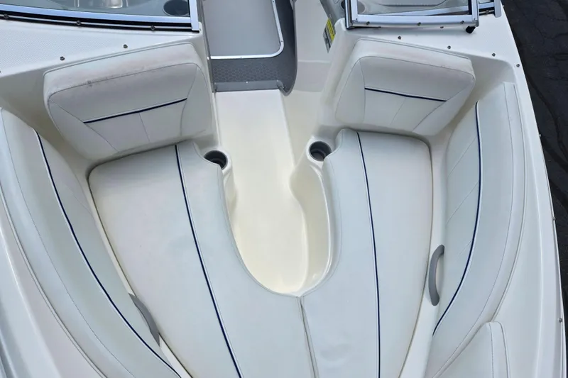 Slide: The Image of 2006 Bayliner 195 Classic boat interior with white cushioned seating and cup holders. - 18