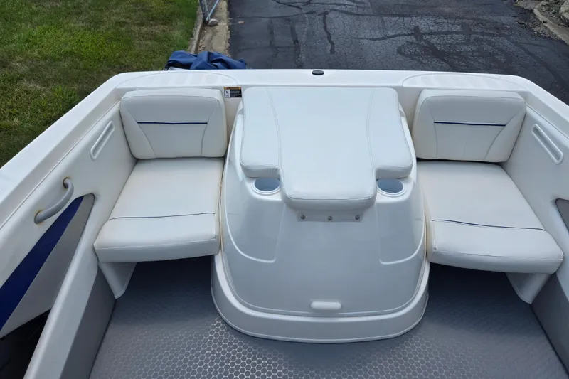 Slide: The Image of 2006 Bayliner 195 Classic boat interior with white seating and cup holders. - 21