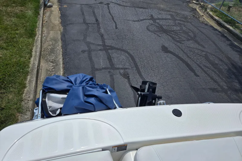 Slide: The Image of 2006 Bayliner 195 Classic boat on a paved road with blue cover. - 23