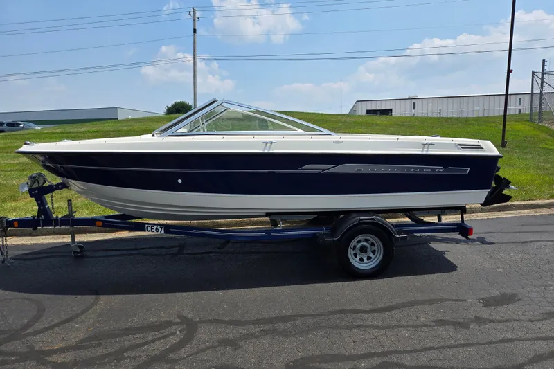 Slide: The Image of 2006 Bayliner 195 Classic boat on trailer, parked outdoors under a clear sky. - 4