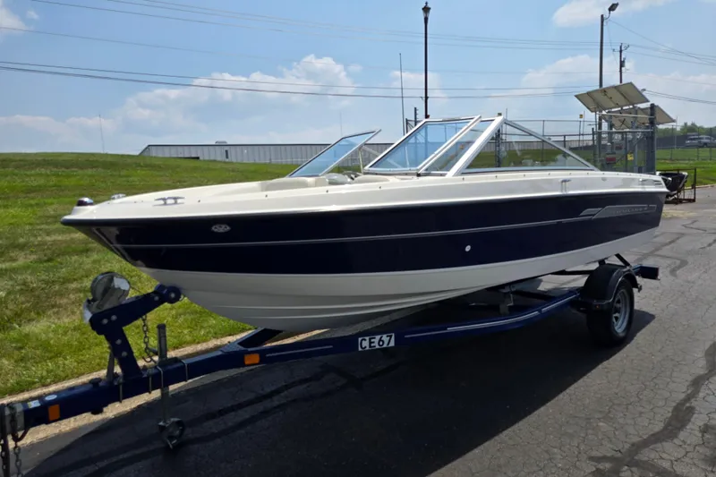 Slide: The Image of 2006 Bayliner 195 Classic boat on trailer, parked outdoors under a clear sky. - 5